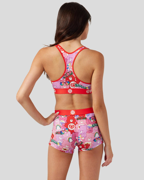 Red and pink Care Bears-print sports bra and shorts set with colorful character graphics and red trim.