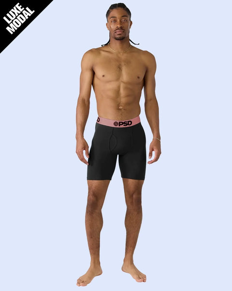 Man wearing black boxer briefs with rose gold waistband and PSD logo.