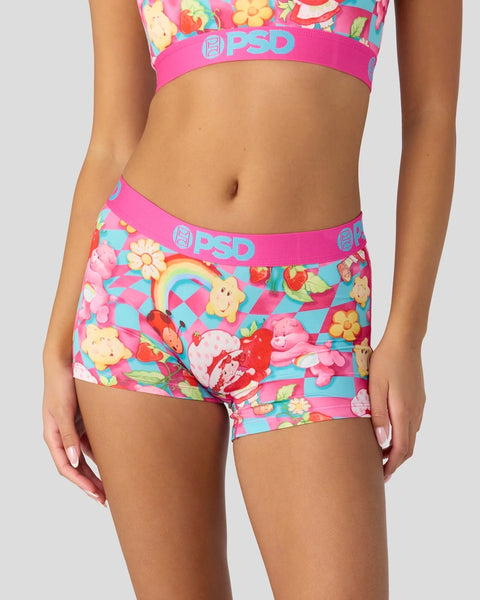 PSD underwear with colorful Strawberry Shortcake and Care Bears characters on pink and turquoise checkered background.