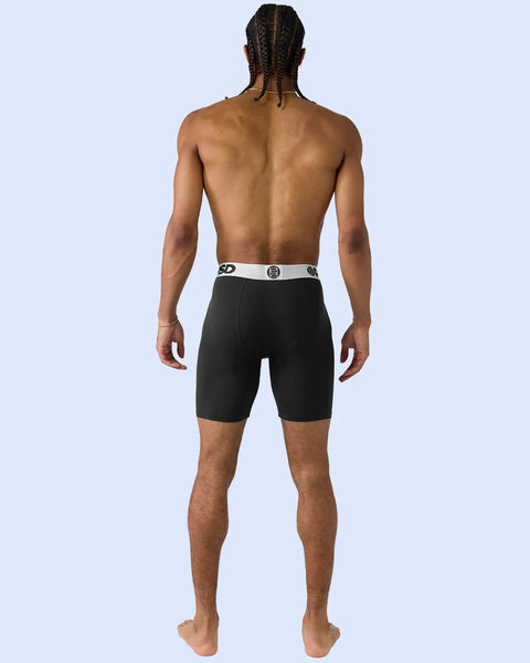 Black boxer briefs with silver-toned waistband featuring brand logo, shown on model from behind.