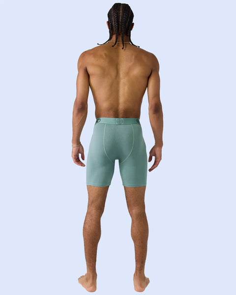 Man wearing sage green modal boxer briefs with elastic waistband, shown from back view.