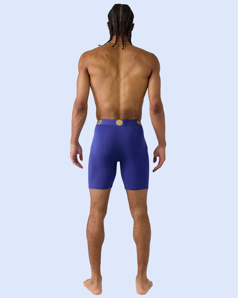 Man wearing royal blue boxer briefs with gold belt buckle, shown from behind.