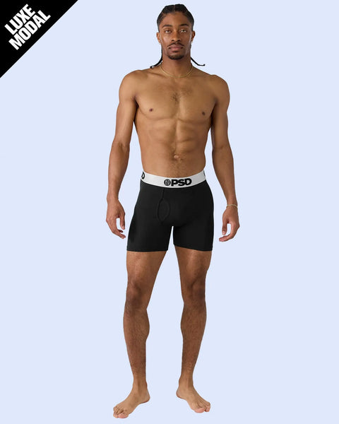 Man wearing black boxer briefs with white and silver waistband.