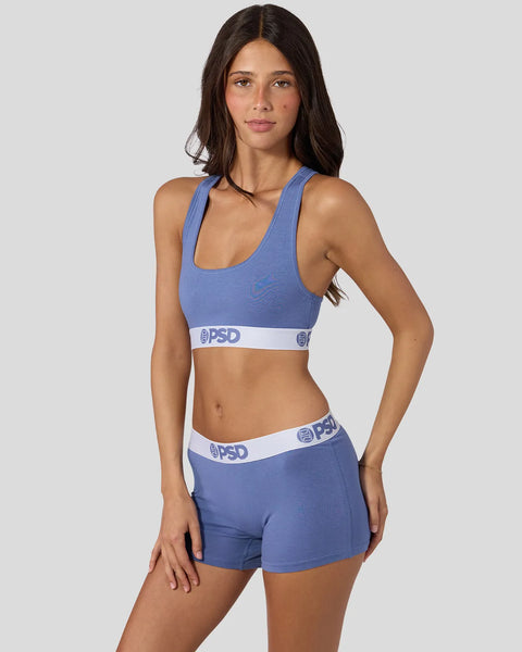 Woman wearing blue denim sports bra and matching shorts with white PSD waistband.