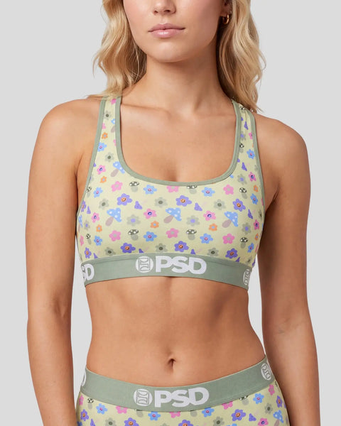 Cream-colored sports bra with colorful mushroom print, green trim, and PSD waistband.
