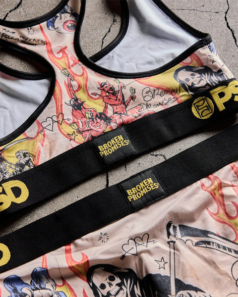 Cream sports bra with red and yellow flame graphics, black straps, and 
