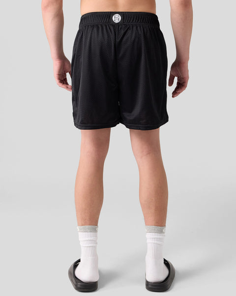 Black mesh athletic shorts with elastic waistband and branded button detail on a male model.
