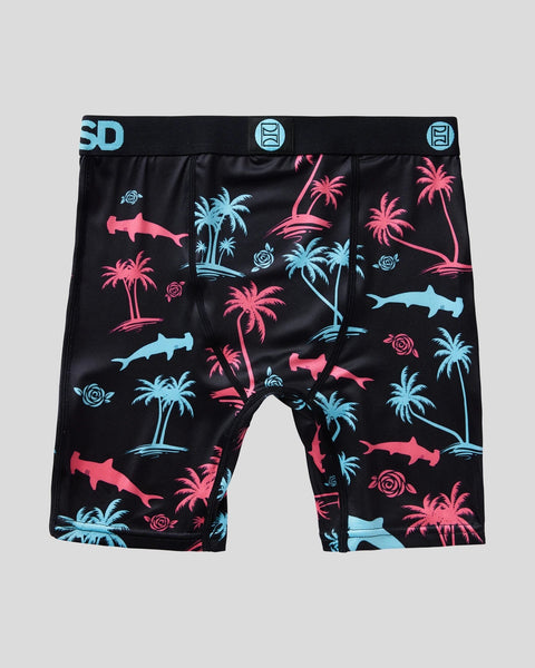 Black boxer shorts with pink and blue shark and palm tree print, elastic waistband with blue logo label.