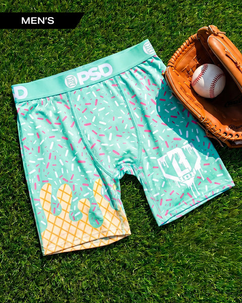Turquoise and yellow ice cream cone patterned men's boxer briefs on grass with baseball glove and ball.